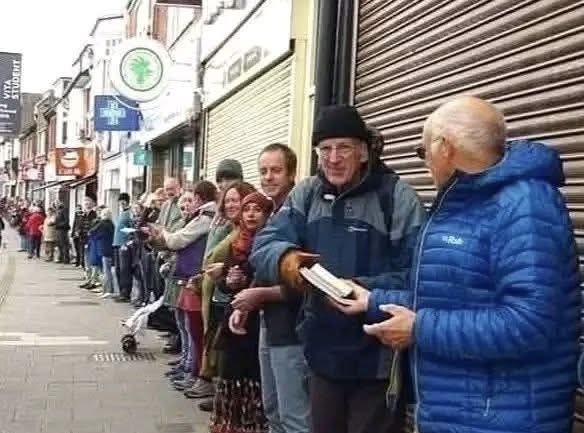 250-dən çox könüllü kitab mağazasını bir saatda köçürdü